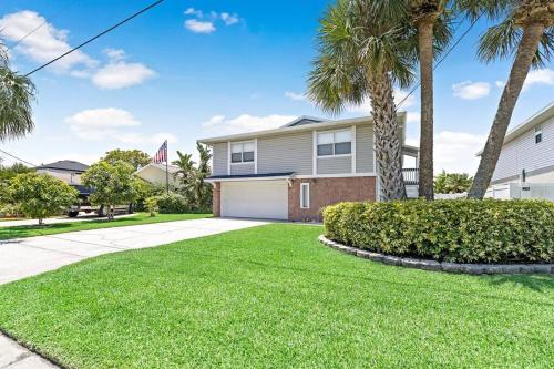 a house with palm trees and a driveway at Waterfront home with pool and gameroom! in Hernando Beach