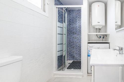 uma casa de banho branca com um chuveiro e um lavatório. em Acuarium 3-19-E Apartment Levante Beach em Benidorm