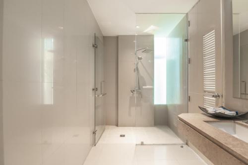 a white bathroom with a shower and a sink at The Lantern Resorts Patong - SHA Extra Plus in Patong Beach