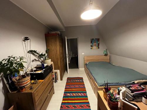 1 dormitorio con cama, mesa y alfombra en ghimbav home's, en Ghimbav