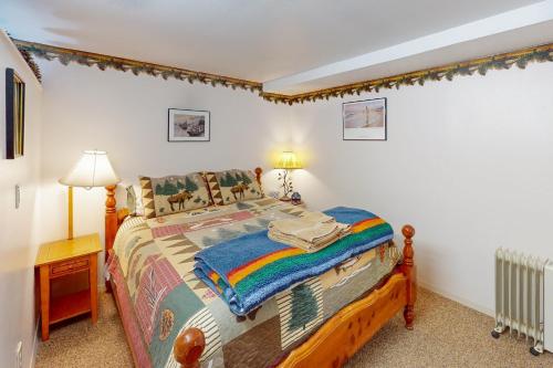 Joseph的住宿－60073 Wallowa Lake Hwy (lower unit)，一间卧室配有一张带彩虹毯子的床