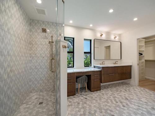 een badkamer met een douche, een wastafel en een spiegel bij Secluded Bayfront Haven in Bonita Springs