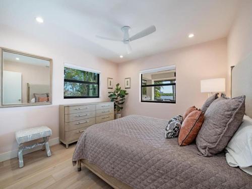 een slaapkamer met een bed, een dressoir en 2 ramen bij Secluded Bayfront Haven in Bonita Springs