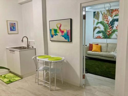 a kitchen with a sink and a table and a couch at Tropical Apartments in Miramar in San Juan