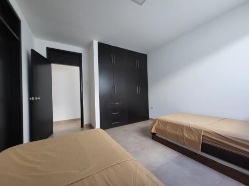 1 dormitorio con 1 cama y armarios negros en Suite Dptm BRISAMAR Playa Santa Marianita Manta, en Manta