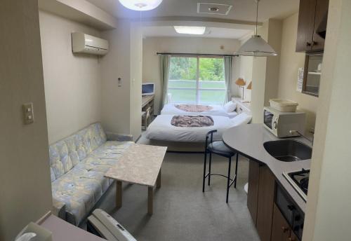 een kamer met 2 bedden en een keuken met een wastafel bij Jozankei Condominium - Vacation STAY 15257 in Jozankei