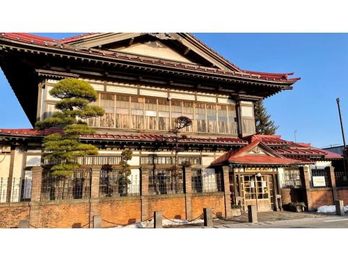a building with a tree in front of it at Hotel Sunroute Patio Goshogawara - Vacation STAY 30369v in Goshogawara