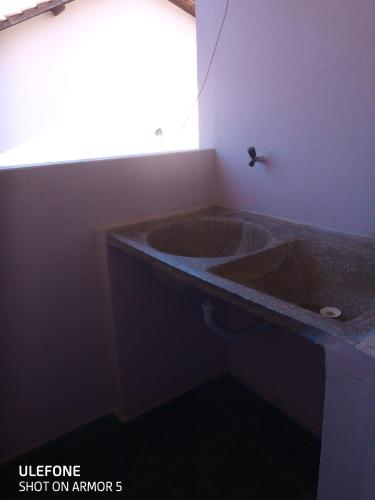 a bathroom with a large stone sink in a room at Residencial Bahia Sol in Nova Viçosa