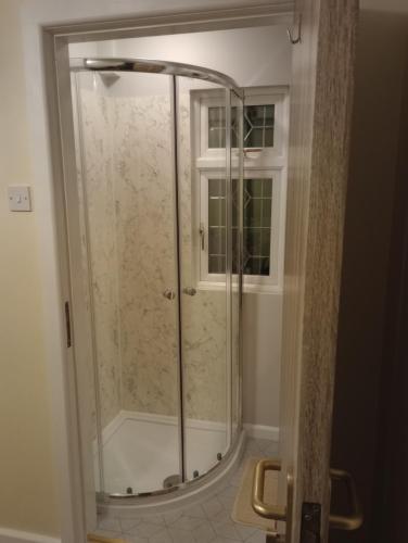 La salle de bains est pourvue d'une douche avec une porte en verre. dans l'établissement QT, à Gildingwells