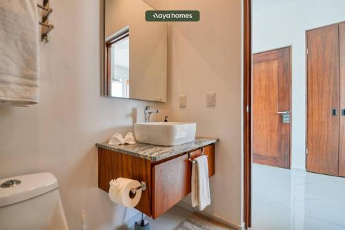 a bathroom with a sink and a toilet and a mirror at Amazing 1BR w/Rooftop Pool in Puerto Vallarta