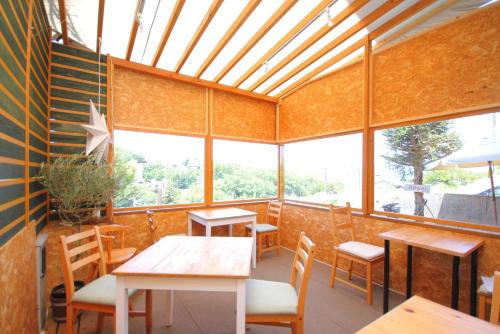 un restaurant avec des tables, des chaises et des fenêtres dans l'établissement Time Traveler Izu-Shuzenji Onsen - Vacation STAY 32421v, à Izu