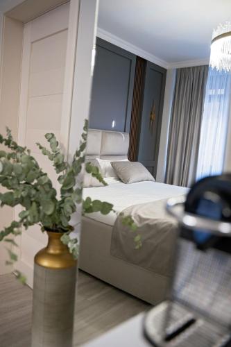 a hotel room with a bed and a vase with flowers at ELISIA STUDIO in Oradea