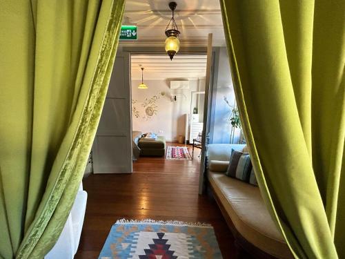 a living room with green curtains and a couch at Tilas - Rooms in 19th Century Wooden Townhouse,Kadikoy in Istanbul