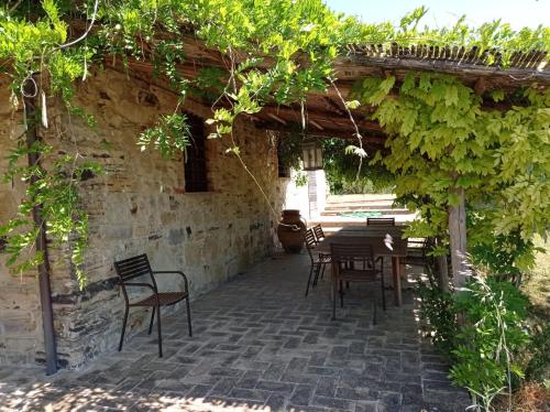 a patio with a table and chairs under a pergola at B&B Casale Ormano in San Venanzo