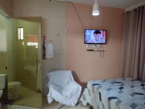a bathroom with a bed and a tv on the wall at Casa mobiliada de 1 quarto na R Oliveira Alves Fontes, 597 - 597 A - Jardim Gonzaga in Juazeiro do Norte