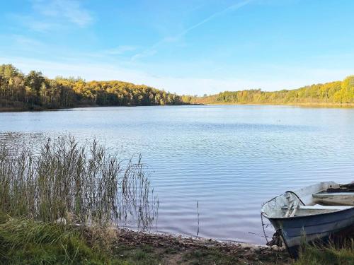 a boat sitting on the shore of a lake at 6 person holiday home in Olofström-By Traum in Olofström