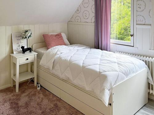 a bedroom with a white bed and a window at Holiday home Grängesberg in Grängesberg