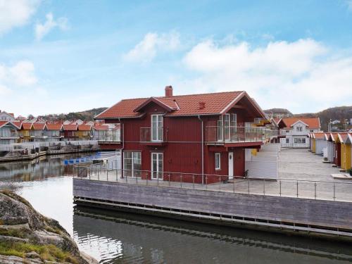 a red house on a dock next to a river at 4 star holiday home in Hamburgsund in Hamburgsund
