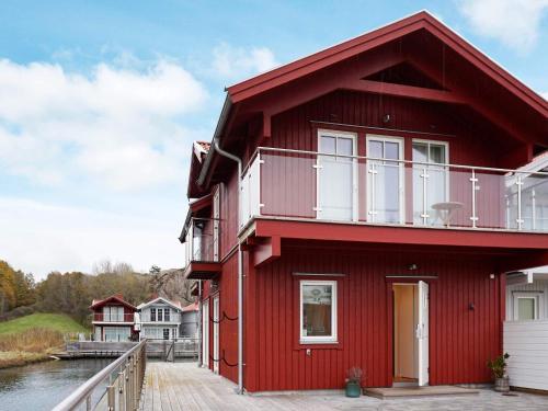 a red house on a dock next to a body of water at 4 star holiday home in Hamburgsund in Hamburgsund