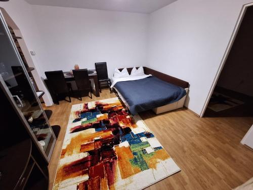 1 dormitorio con cama y alfombra en el suelo en A&M, en Târgu Mureș