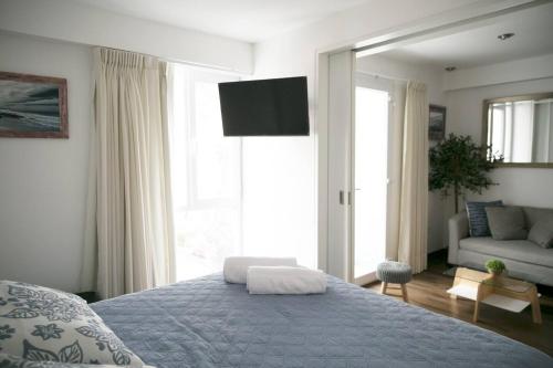 a bedroom with a bed and a couch and a television at Barranco Best Location - Apartment in Lima