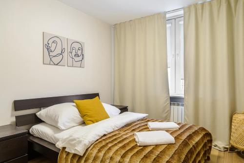 a bedroom with a bed with yellow and white pillows at P&O Apartments Hawajska in Warsaw