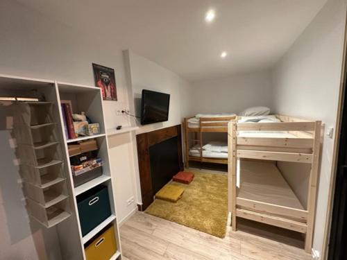 a room with two bunk beds and a tv at Ecueil des Neiges in Barèges