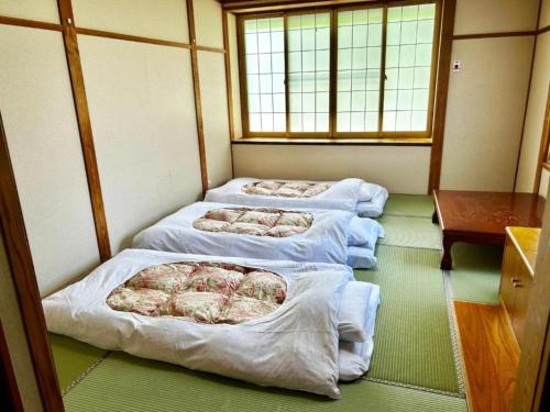 Una fila de cuatro camas en una habitación en Hotel Montblanc Hakuba - Vacation STAY 97806v, en Hakuba