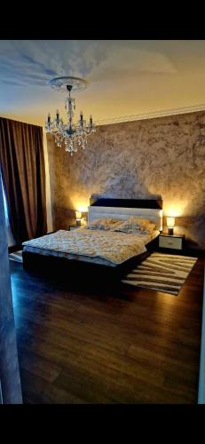 a bedroom with a bed and a chandelier at Dominic House in Turda