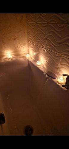 a bathroom with a tub with lights in it at Dominic House in Turda