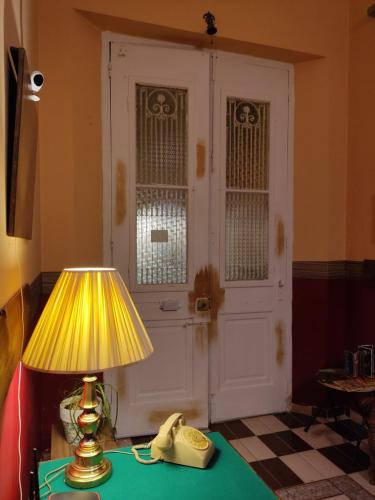 a telephone and a lamp on a table with a door at 1920s Rooms in Kalamata