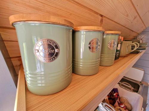 four green coffee cups sitting on a shelf at Bothan Creag Sobhrag in Ballachulish