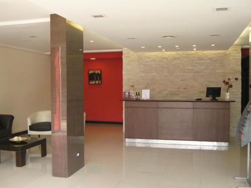vestíbulo con recepción y pared roja en DAKAR HOTEL en Mendoza