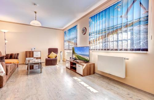 a living room with a tv and a large window at Koserow, Koserower Strand - App in Ostseebad Koserow