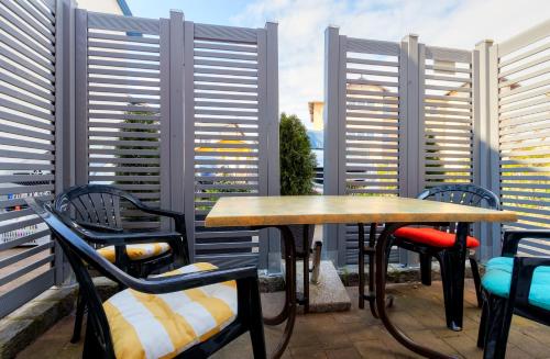 un patio con 2 tavoli, sedie e finestre di Koserow, Koserower Strand - App a Ostseebad Koserow