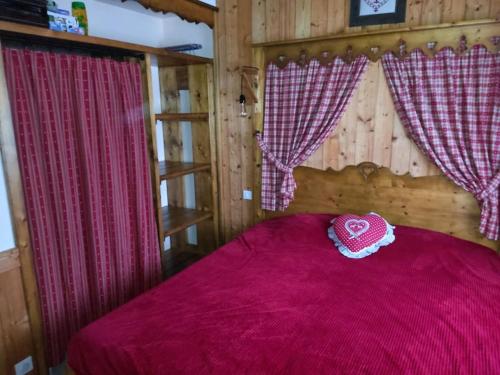 a bed with a pink bedspread with a heart on it at Le Chalet du Bucheron in Gérardmer
