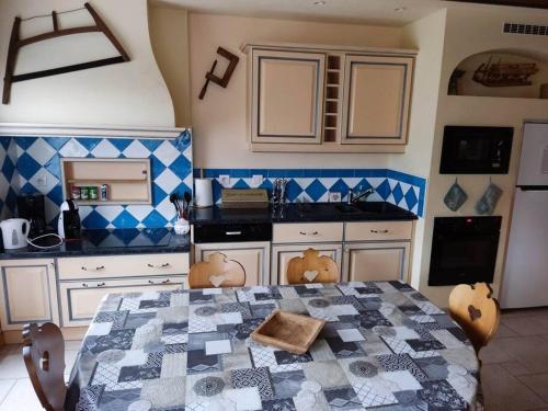 une cuisine avec une table et des chaises dans une pièce dans l'établissement Le Chalet du Bucheron, à Gérardmer