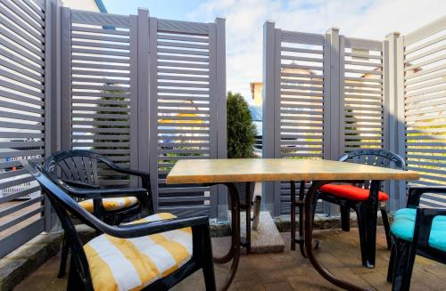 a patio with two tables and chairs and windows at Koserow, Koserower Strand - App in Ostseebad Koserow