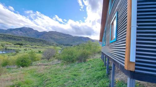a building with a view of the mountains at Refugio del río, a orillas del río Cochrane in Cochrane