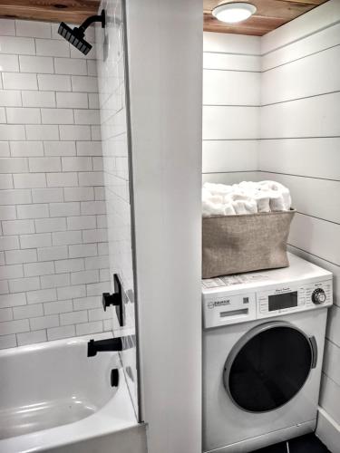 a washing machine in a bathroom next to a tub at Tiny Home Big Fun in Knoxville