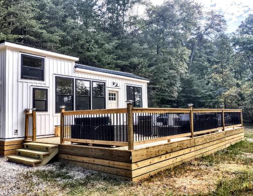 a tiny house with a wooden deck in the yard at Tiny Home Big Fun in Knoxville