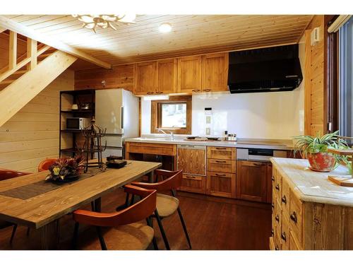 une cuisine avec des placards en bois et une table avec des chaises dans l'établissement Class Vesso Tateshina - Vacation STAY 51898v, à Chino