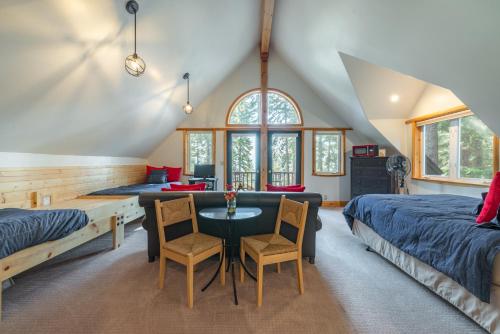 una camera da letto con due letti, un tavolo e delle sedie di Ember Ridge Retreat by Tahoe Getaways - 3BR Pet-Friendly Carnelian Bay Rental w Fenced Yard, Ping Pong, Hot Tub, Near Northstar a Carnelian Bay