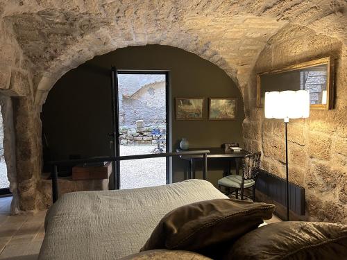 une chambre avec un lit et un mur en pierre dans l'établissement Le Patio, à Uzès