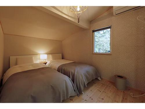 two beds in a room with a window at Class Vesso Tateshina - Vacation STAY 51965v in Chino