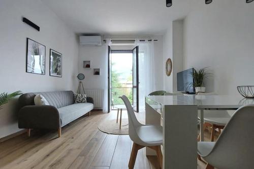 uma sala de estar com um sofá e uma sala de jantar em appartamento Enrica em Lovere