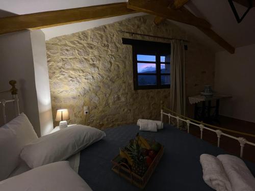 a bedroom with two beds and a window with a basket of fruit at Windy Inns ( Maistros I ) in Vouyiáton