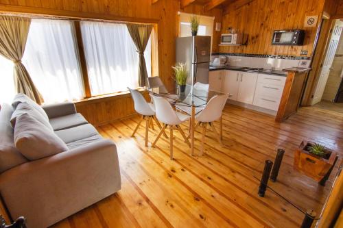 a living room with a couch and a table and chairs at Altos de Pichilemu in Pichilemu