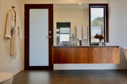 uma casa de banho com um lavatório e um espelho em Eco Waterfront Seclusion - Carlton Bluff House em Primrose Sands