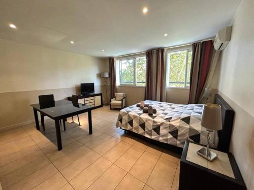 une chambre avec un lit, un bureau et une table dans l'établissement Carnot, à Cannes